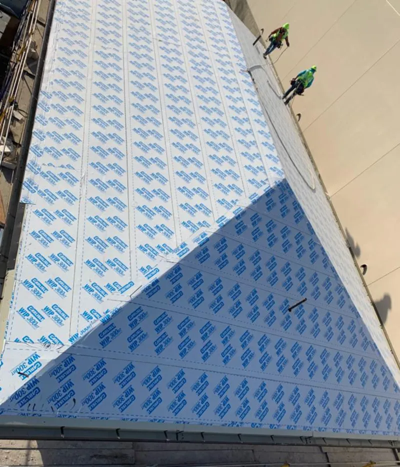 Professional roofers installing underlayment on a metal roof in Birch Run